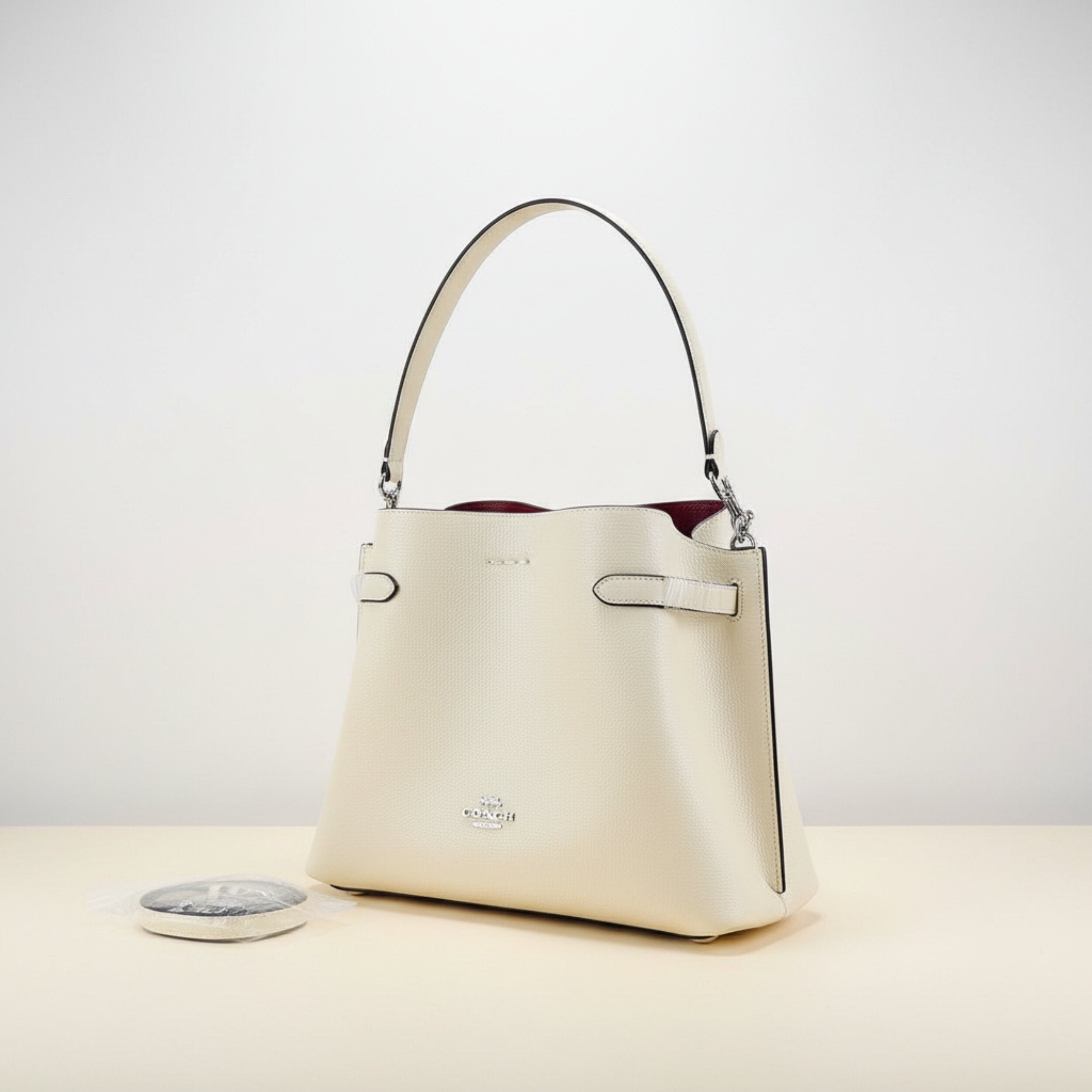 Side view of Coach crossbody bag displaying premium leather quality