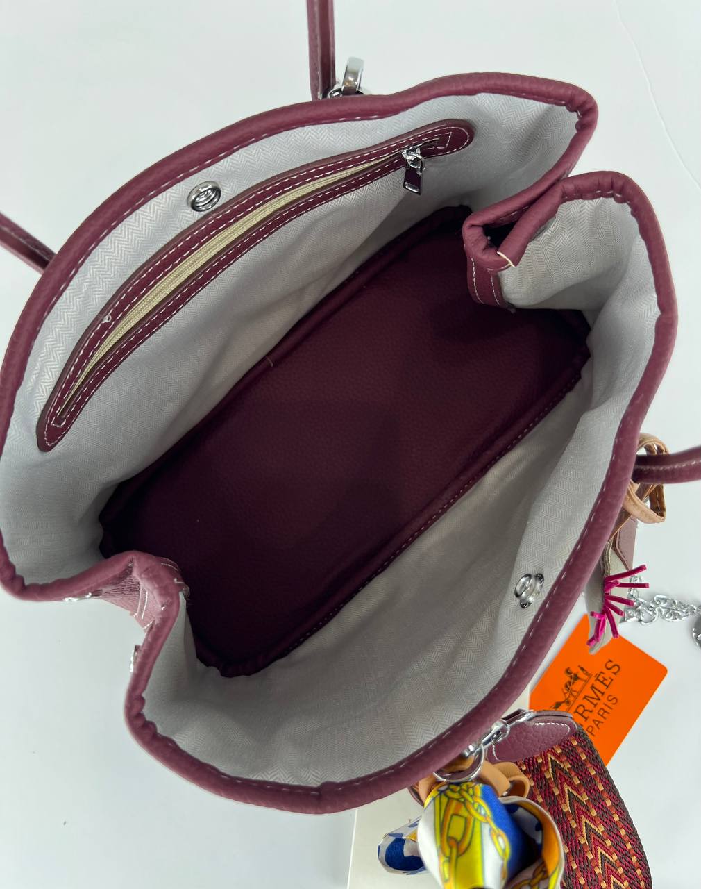 Pink handbag with a visible brand tag on a white background