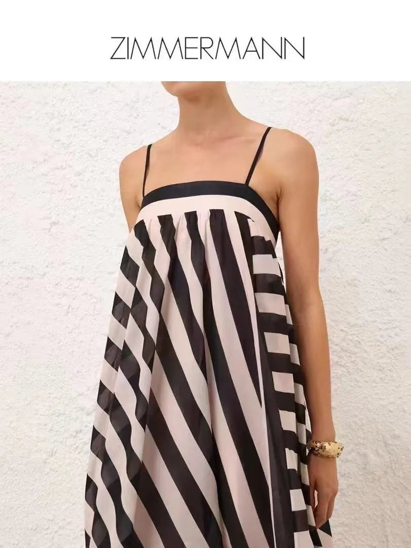 Woman wearing a black and white striped dress with 'Zimmermann' branding on a textured white background.