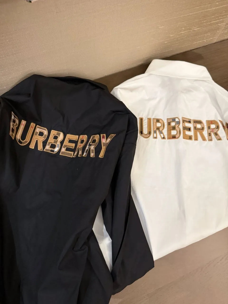Black and white Burberry jackets on a wooden surface