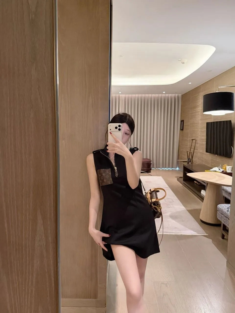 Person wearing a black dress in a modern interior setting