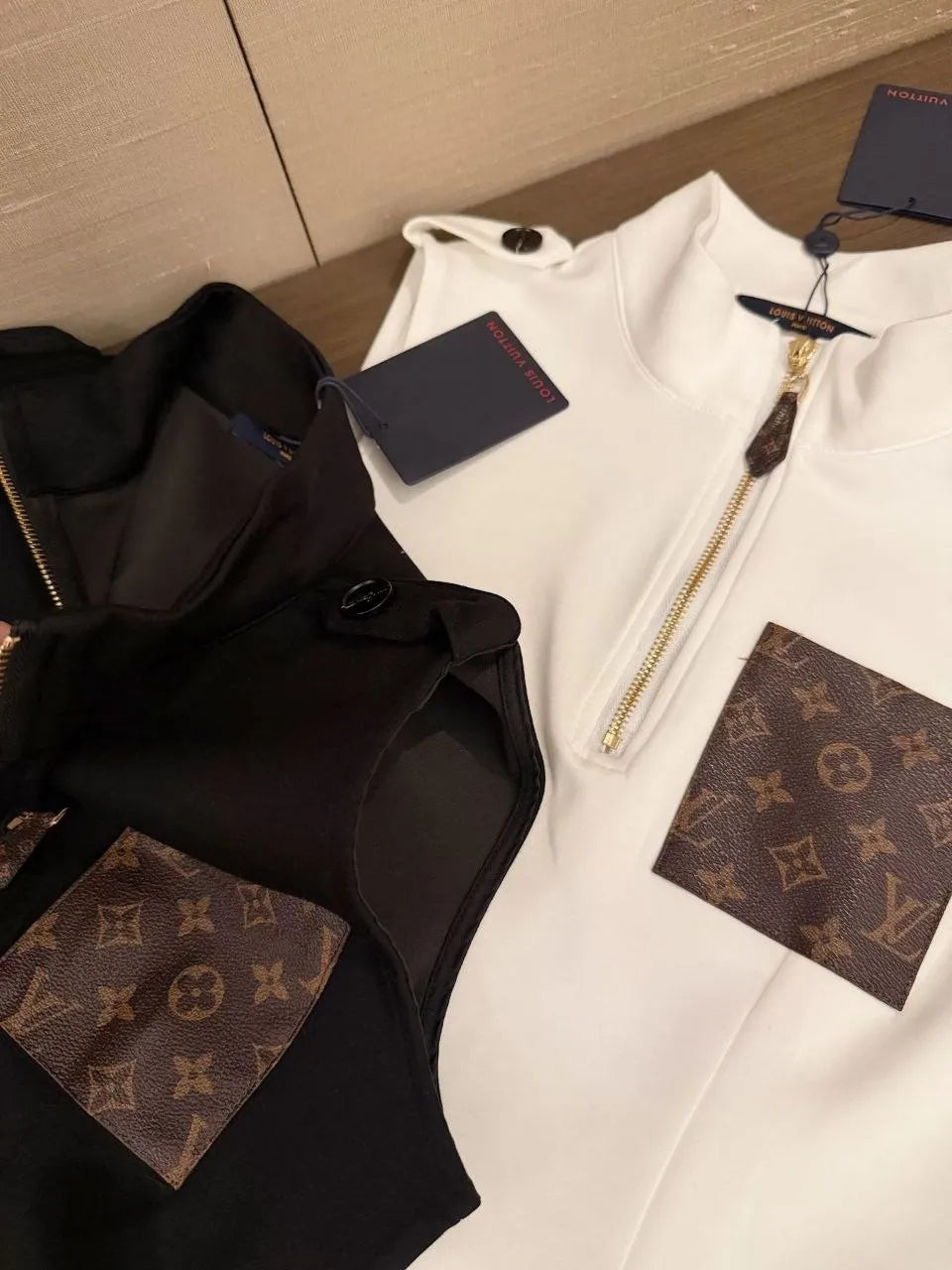 Black and white clothing with Louis Vuitton monogram pattern on a wooden surface
