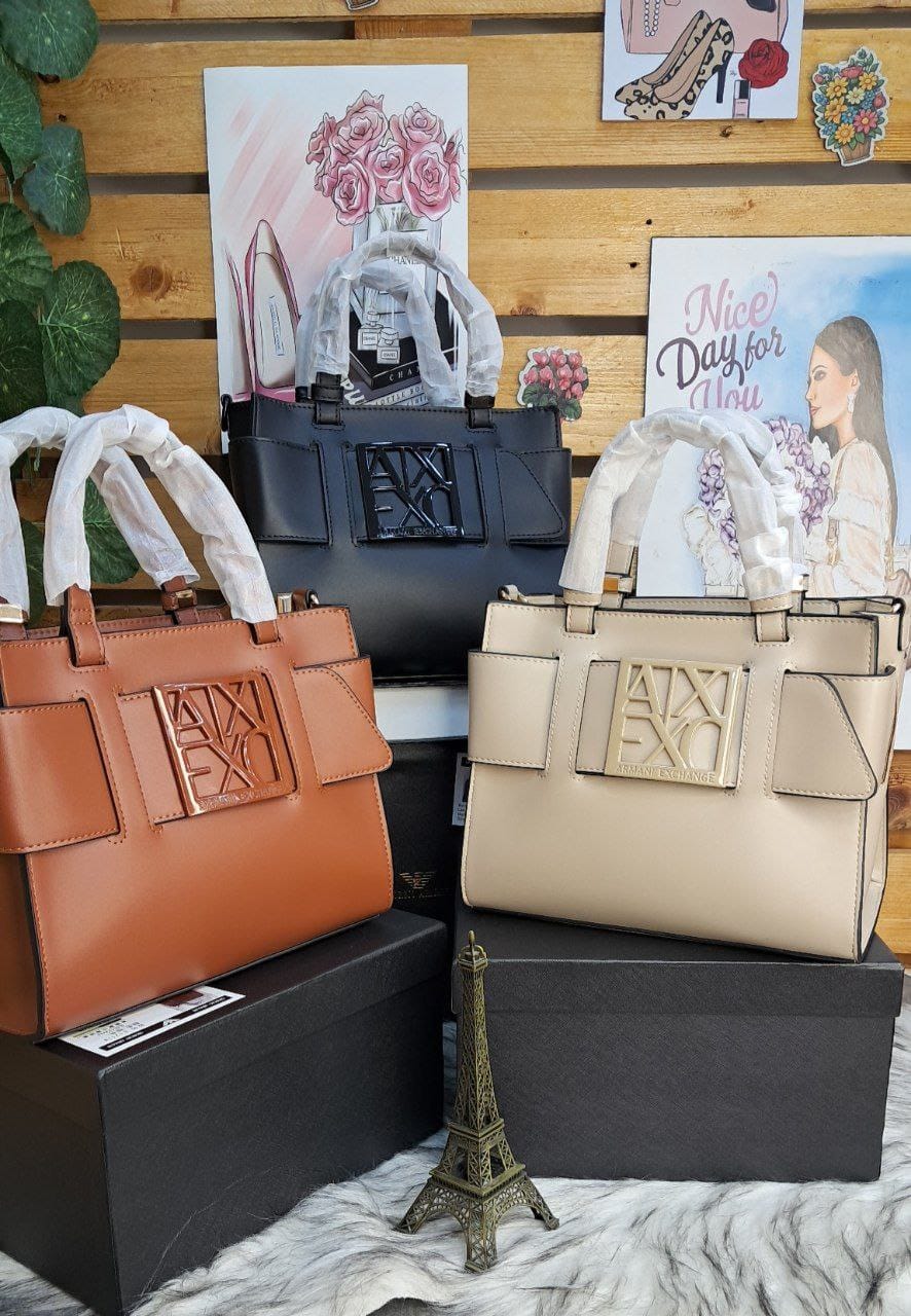 Two handbags, one brown and one beige, on display with decorative items in the background.