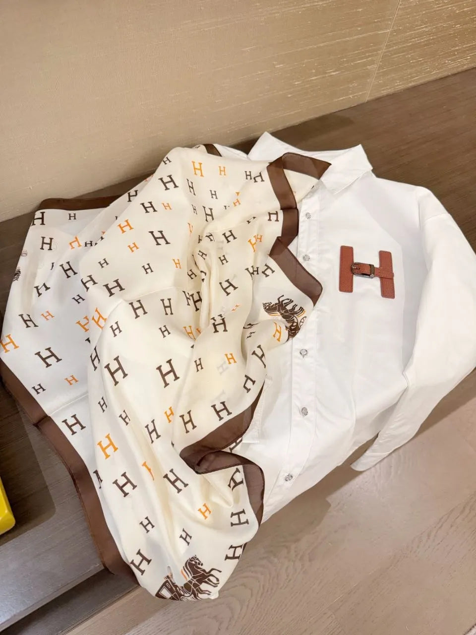 Baby outfit with white shirt and patterned pants on a wooden surface