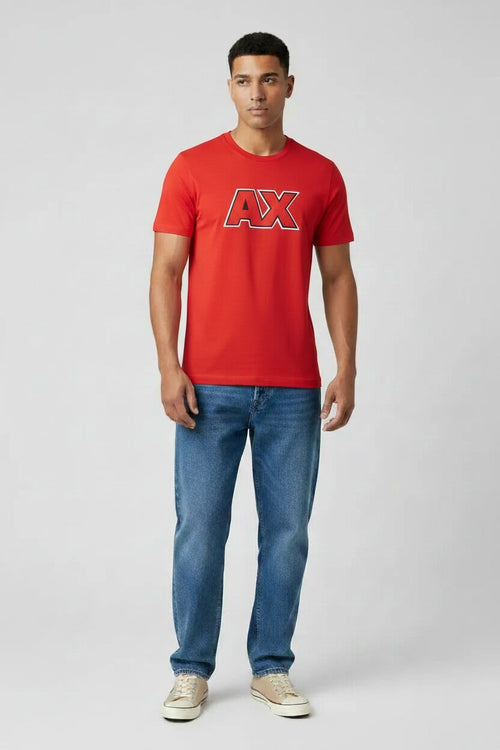 Man wearing a red AX t-shirt and blue jeans on a white background