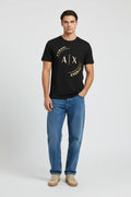 Male model wearing Armani Exchange black AX logo t-shirt with loose fit blue jeans and beige sneakers