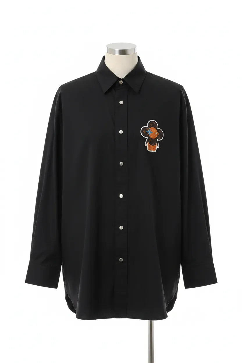 Black shirt with a floral design on a mannequin against a white background