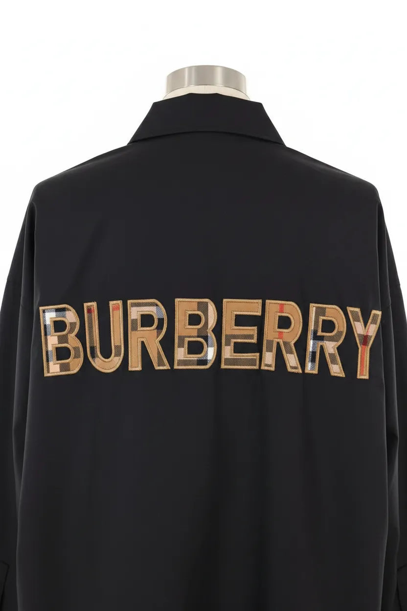 Black Burberry jacket with reflective logo on a white background