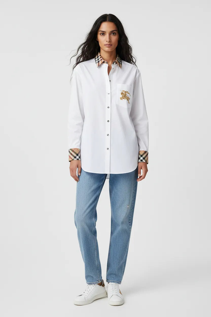 Woman wearing a white shirt with a brand logo and blue jeans on a white background