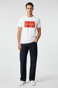 Man wearing a white Calvin Klein t-shirt with a red logo on a white background