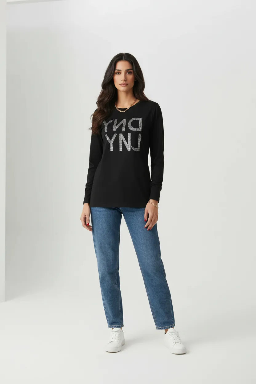 Female model wearing DKNY black rhinestone long sleeve t-shirt relaxed fit blue jeans white sneakers studio background