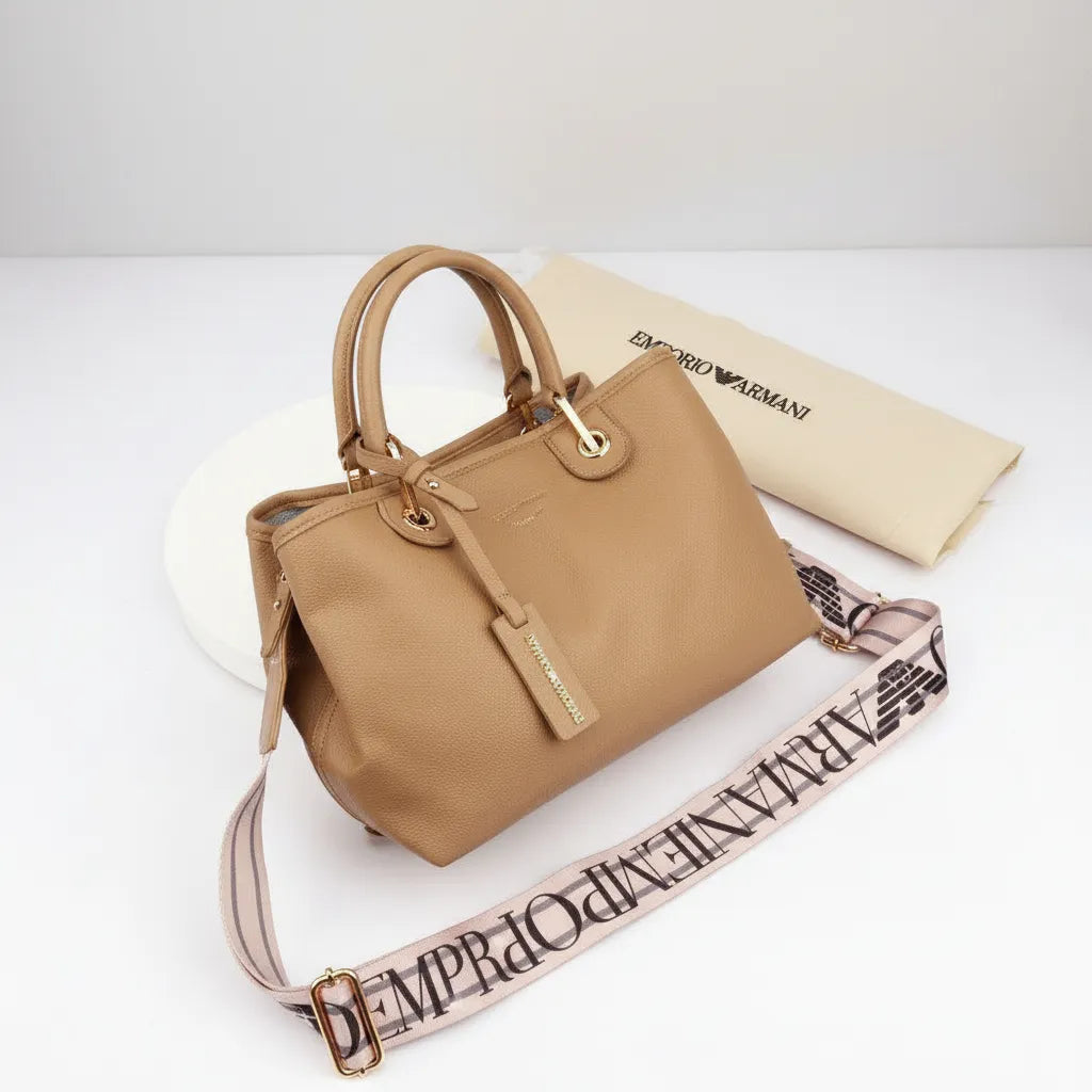 Beige handbag with matching strap on a white background