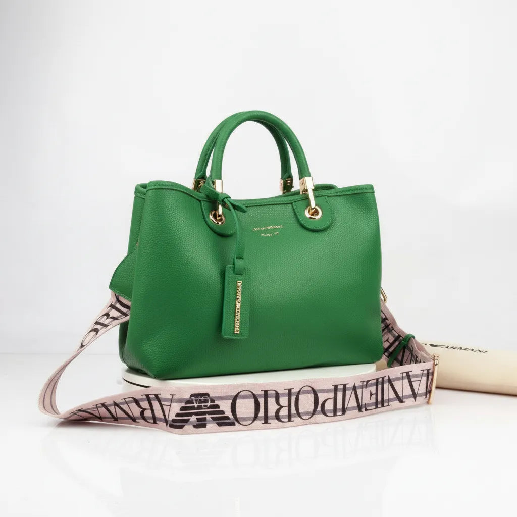 Green handbag with a branded strap on a white background