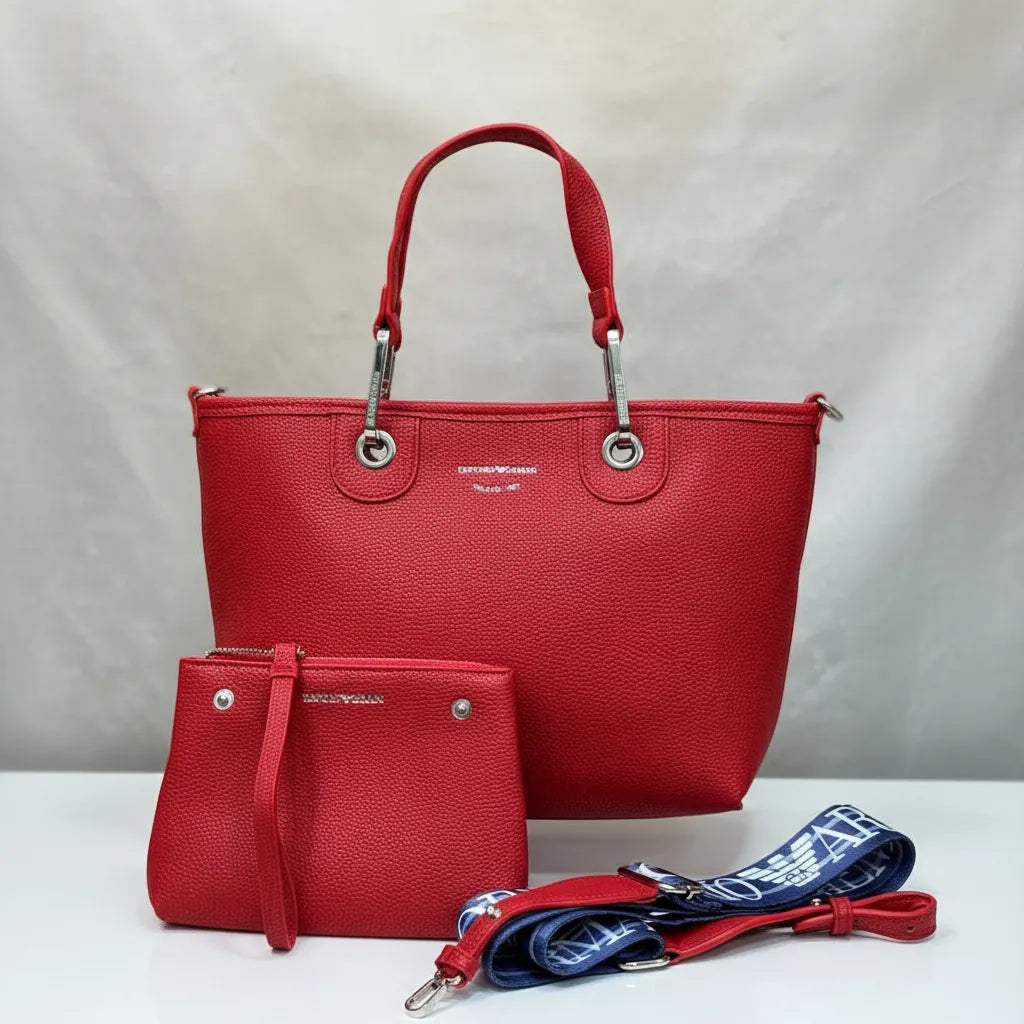 Red handbag with matching wallet and strap on a light gray background