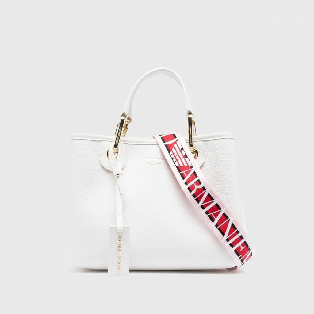 White handbag with a red and black Armani keychain on a white background