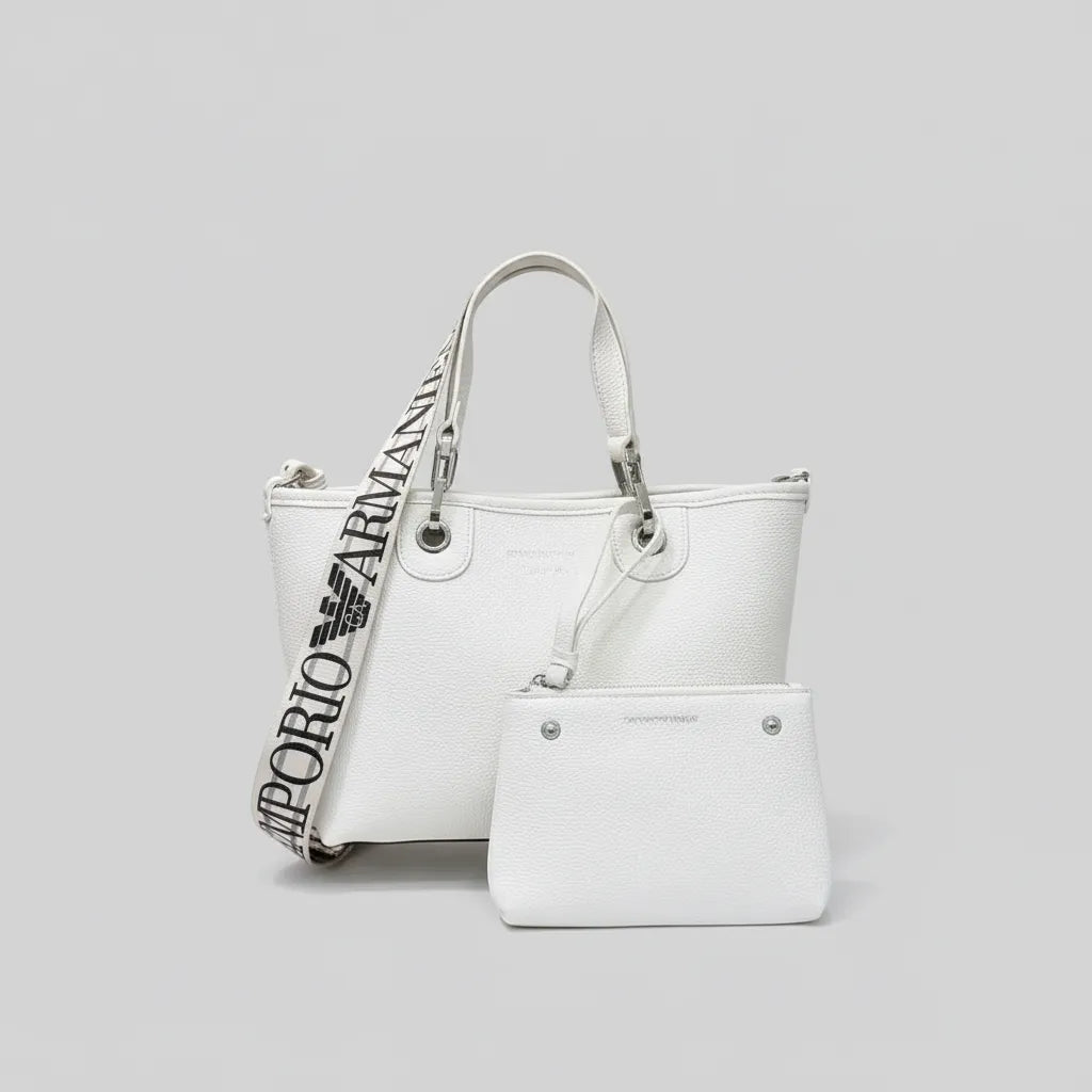 White handbag with a branded strap on a light gray background
