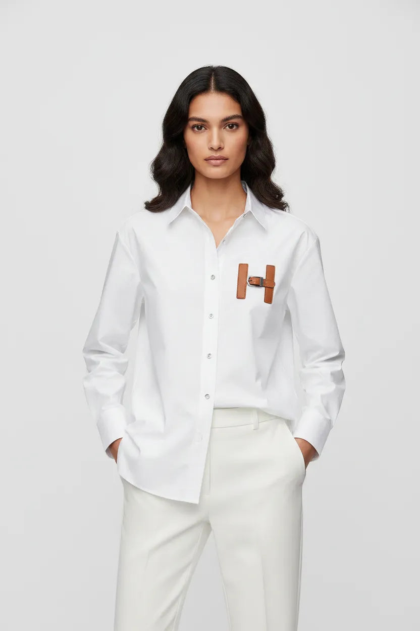 Woman wearing a white shirt with a logo on a plain background