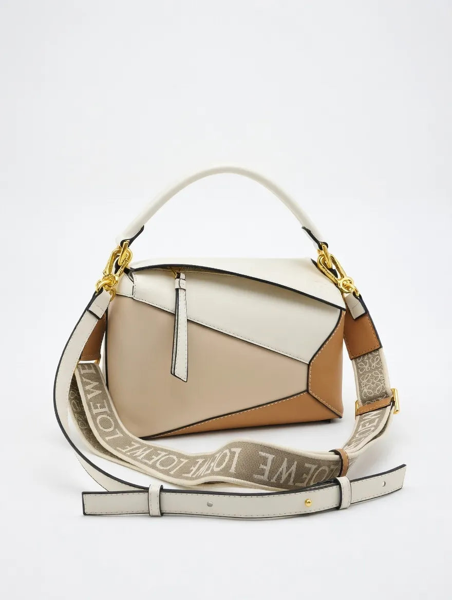 Two-tone handbag with a strap featuring branding on a white background