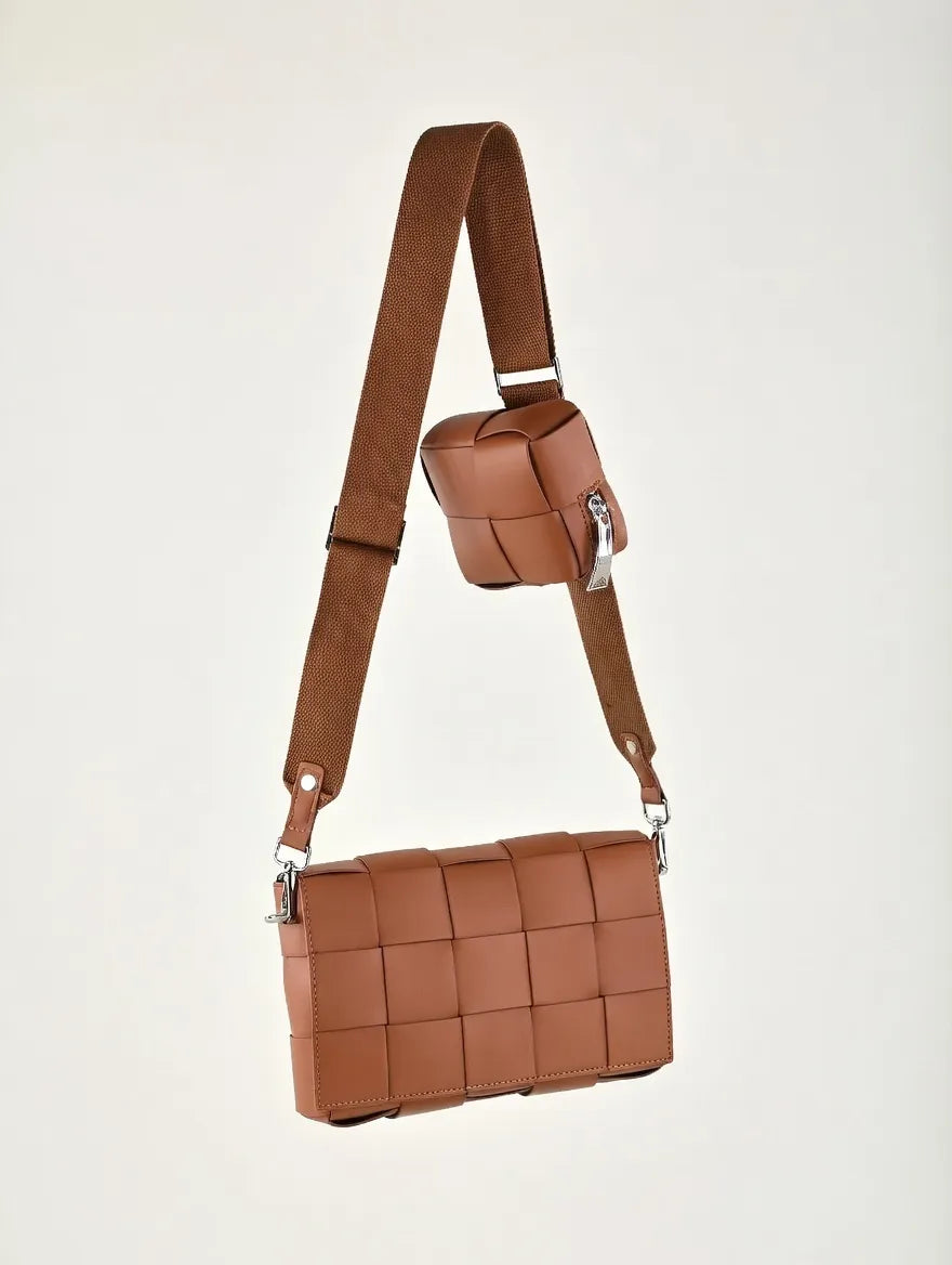 Brown woven handbag with a shoulder strap on a light gray background