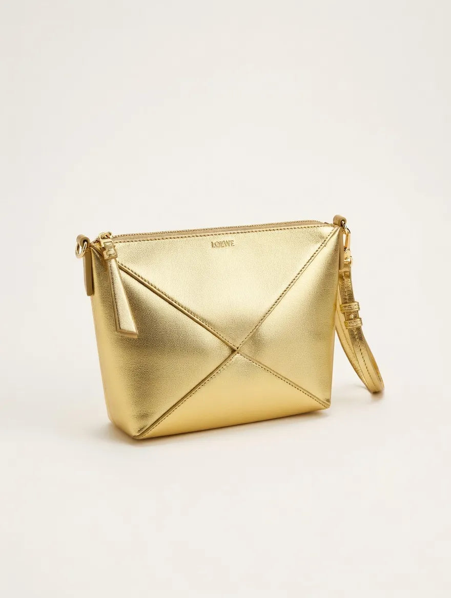 Gold handbag with a geometric design on a light beige background