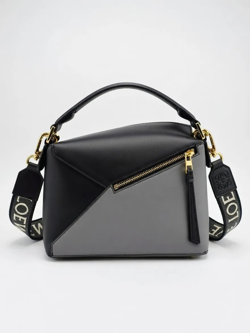 Black and gray handbag with gold accents on a white background