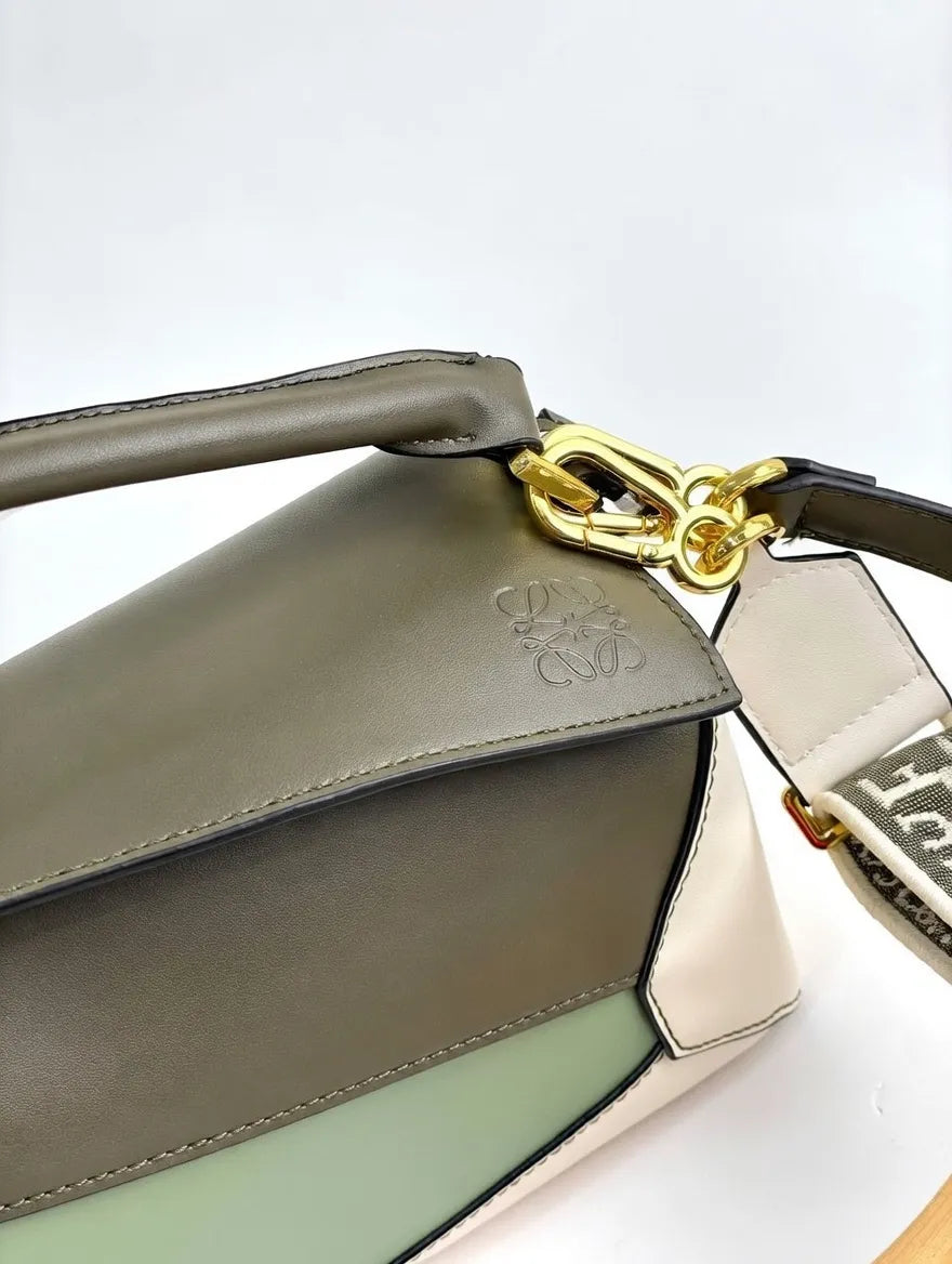 Close-up of a handbag with a gold clasp on a white background