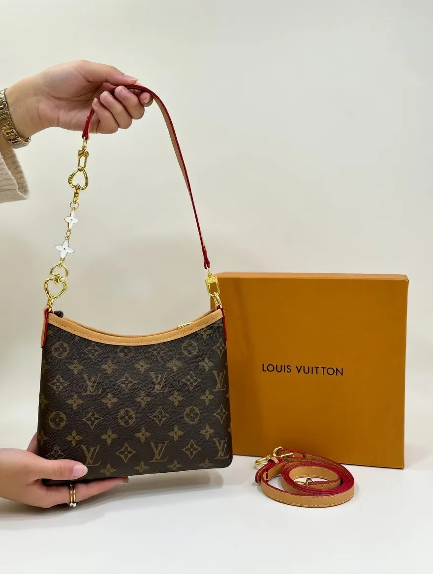 Louis Vuitton handbag with monogram pattern and matching strap, next to a brown box with 'Louis Vuitton' branding.