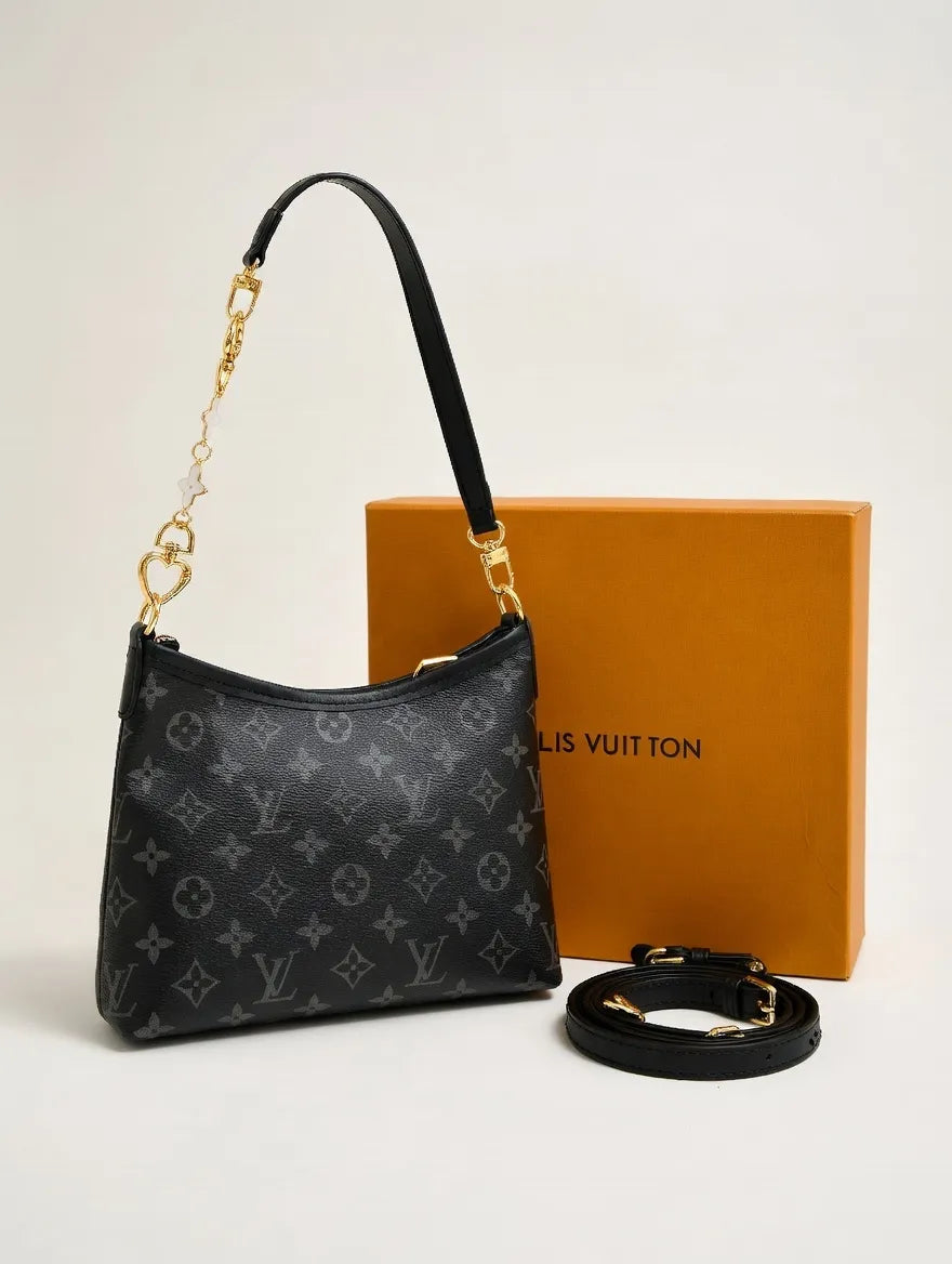 Louis Vuitton handbag with monogram pattern, black strap, and orange box on a light beige background
