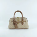 Woven handbag with brown leather accents on a light gray background