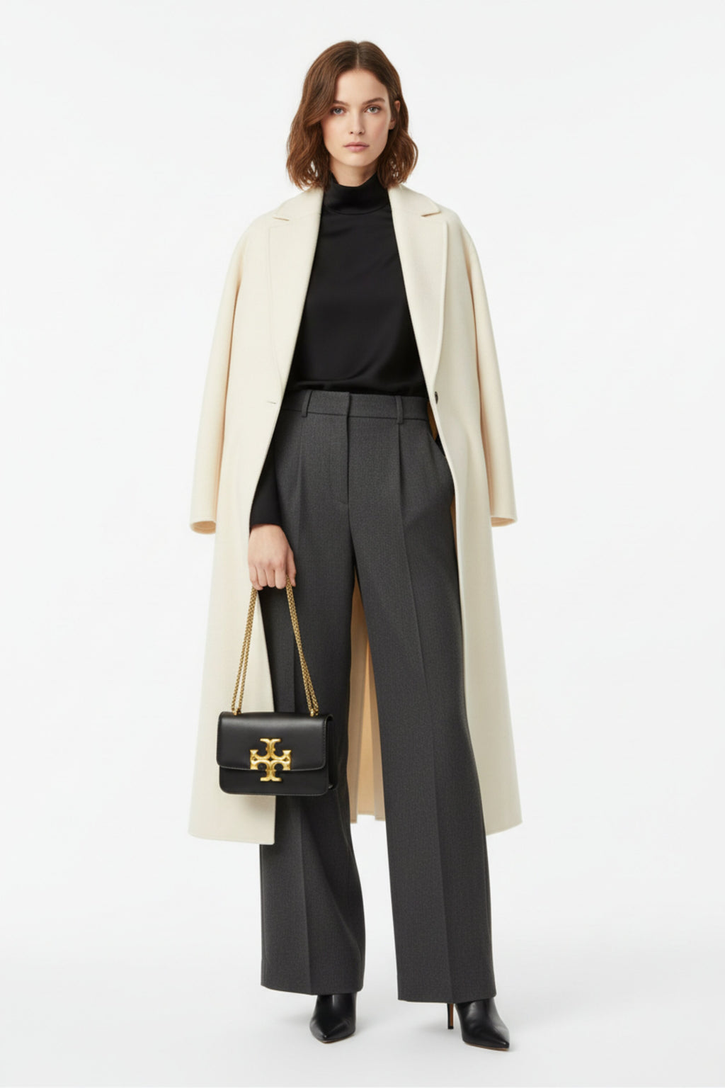 Fashion model carrying Tory Burch Eleanor black leather bag - studio shot
