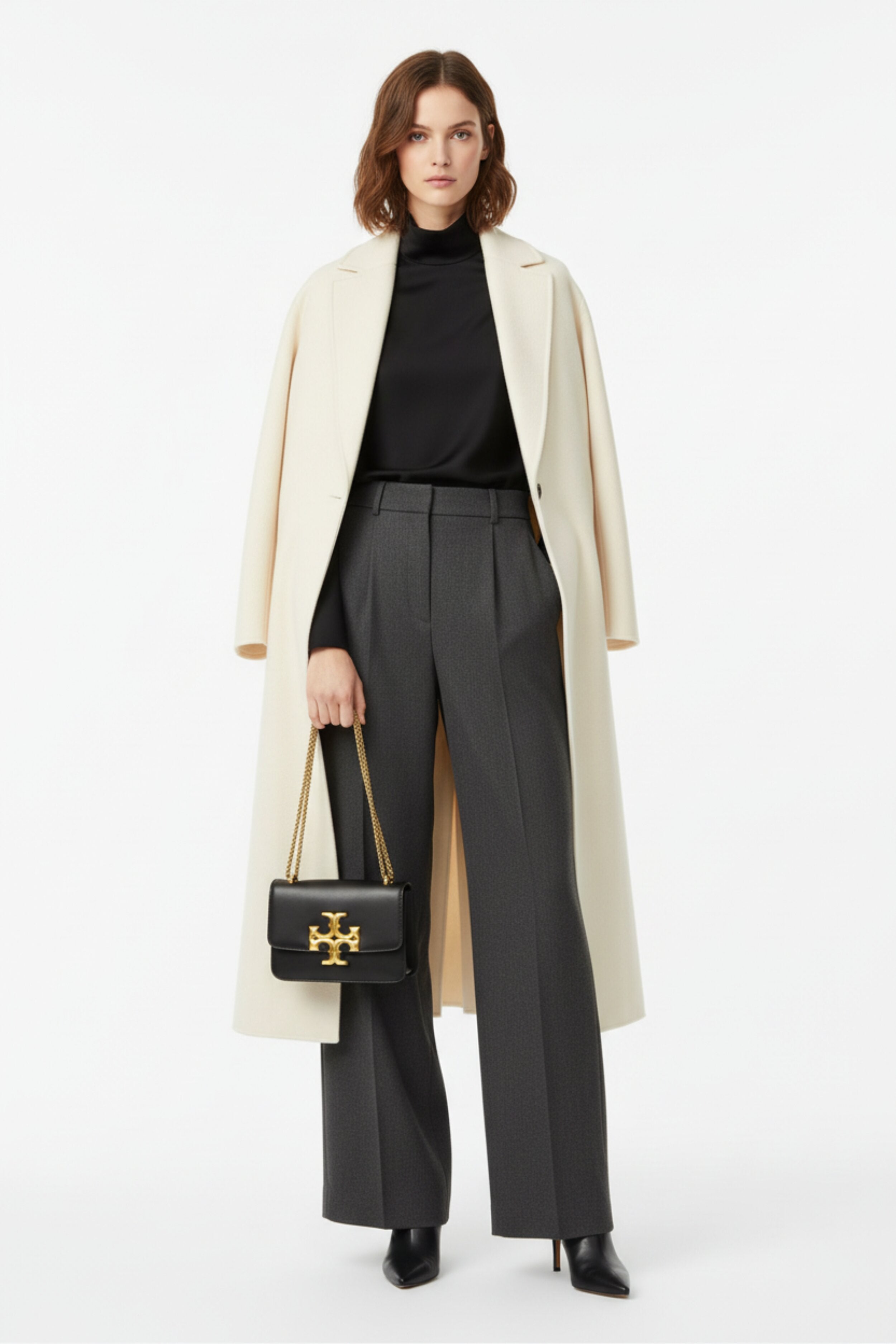 Fashion model carrying Tory Burch Eleanor black leather bag - studio shot
