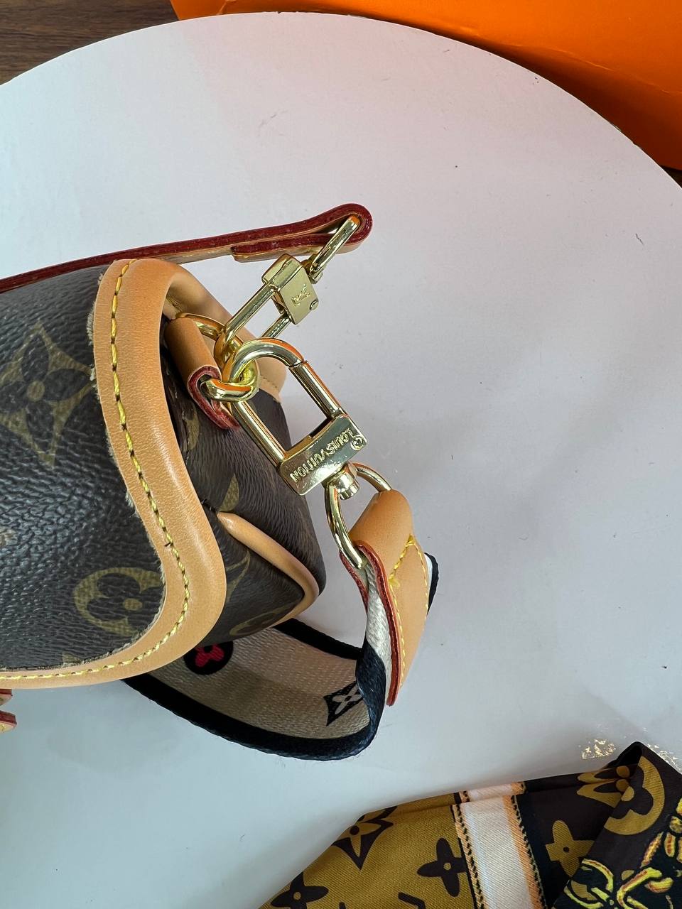 Close-up of a Louis Vuitton keychain on a white surface