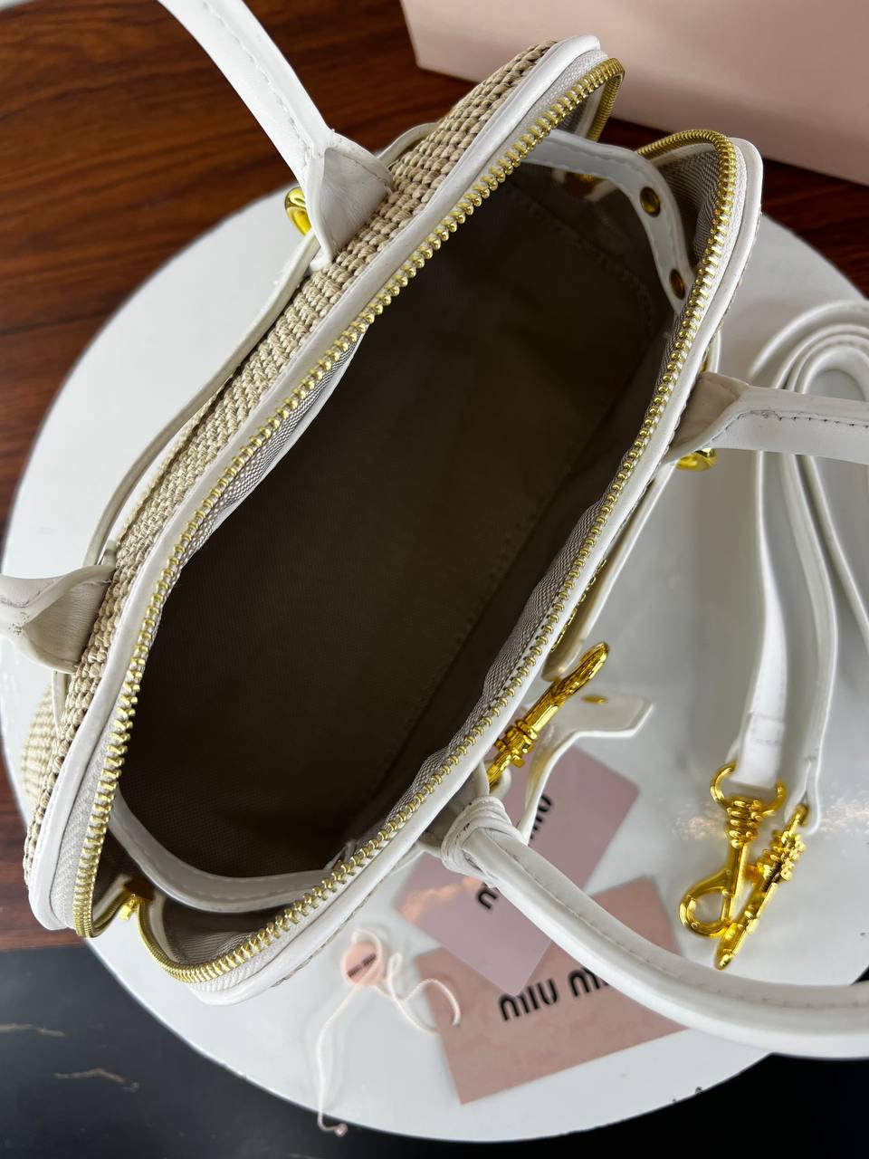 White handbag with gold accents on a white surface
