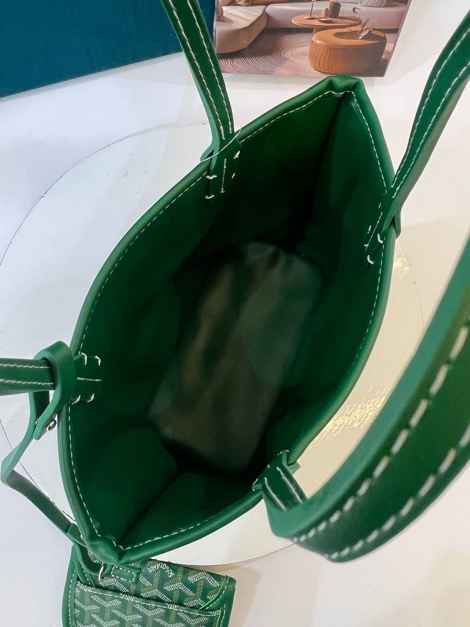 Green handbag with visible brand logo on a white surface