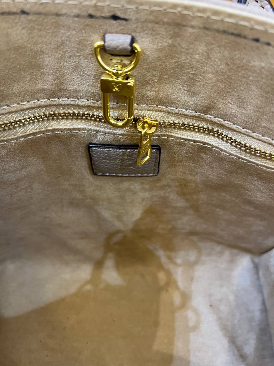 Close-up of a gold zipper on a beige surface