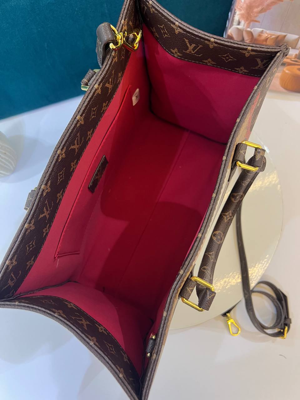 Designer handbag with red interior on a white surface