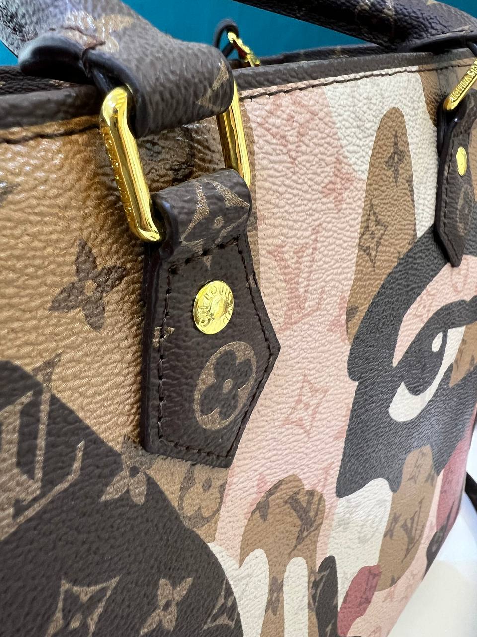 Close-up of a patterned handbag with visible brand logo.