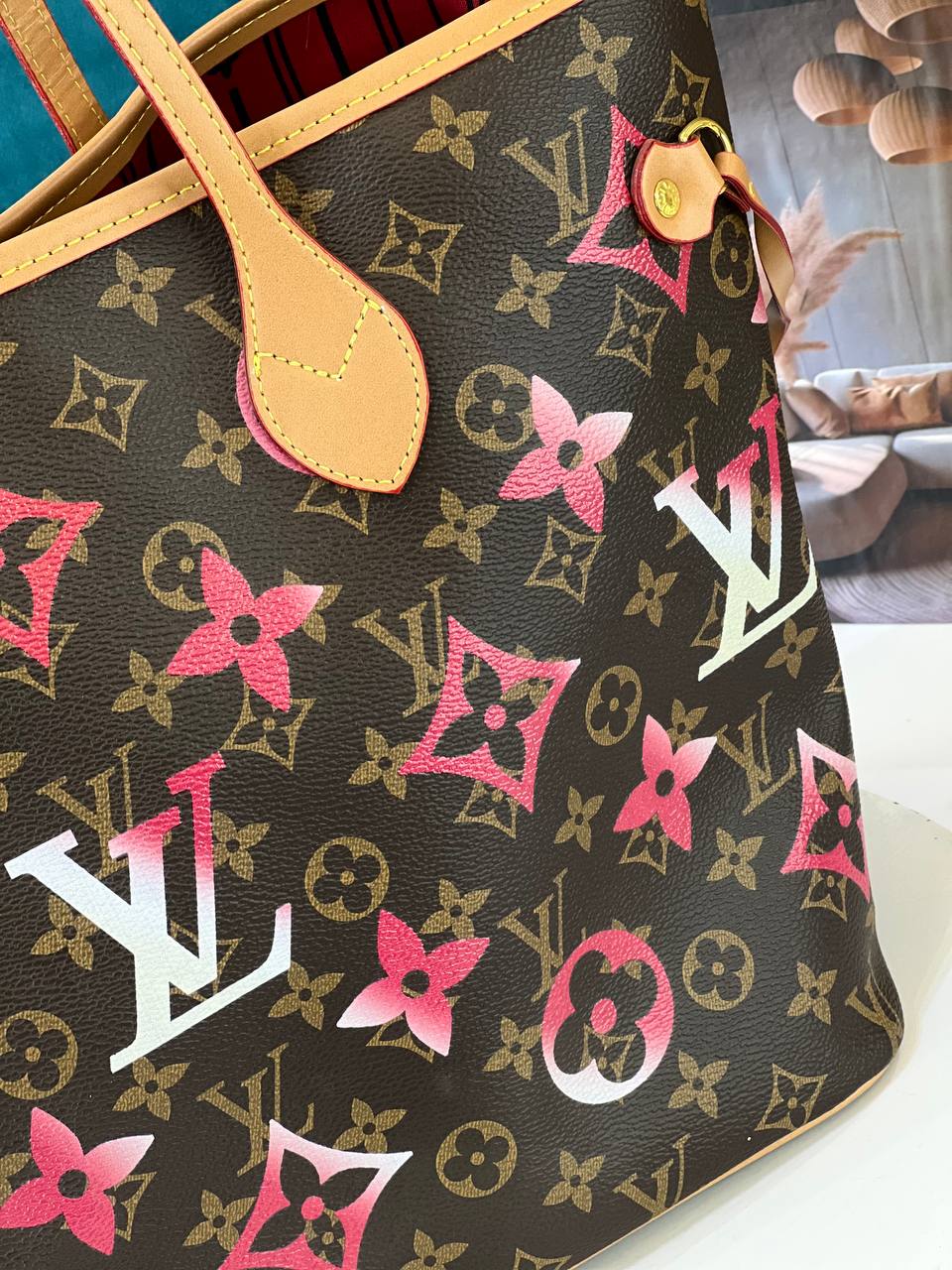 Designer handbag with floral pattern and visible brand logo on a white surface