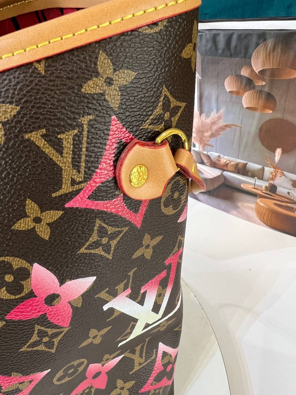 Louis Vuitton handbag with colorful design elements on a blurred background