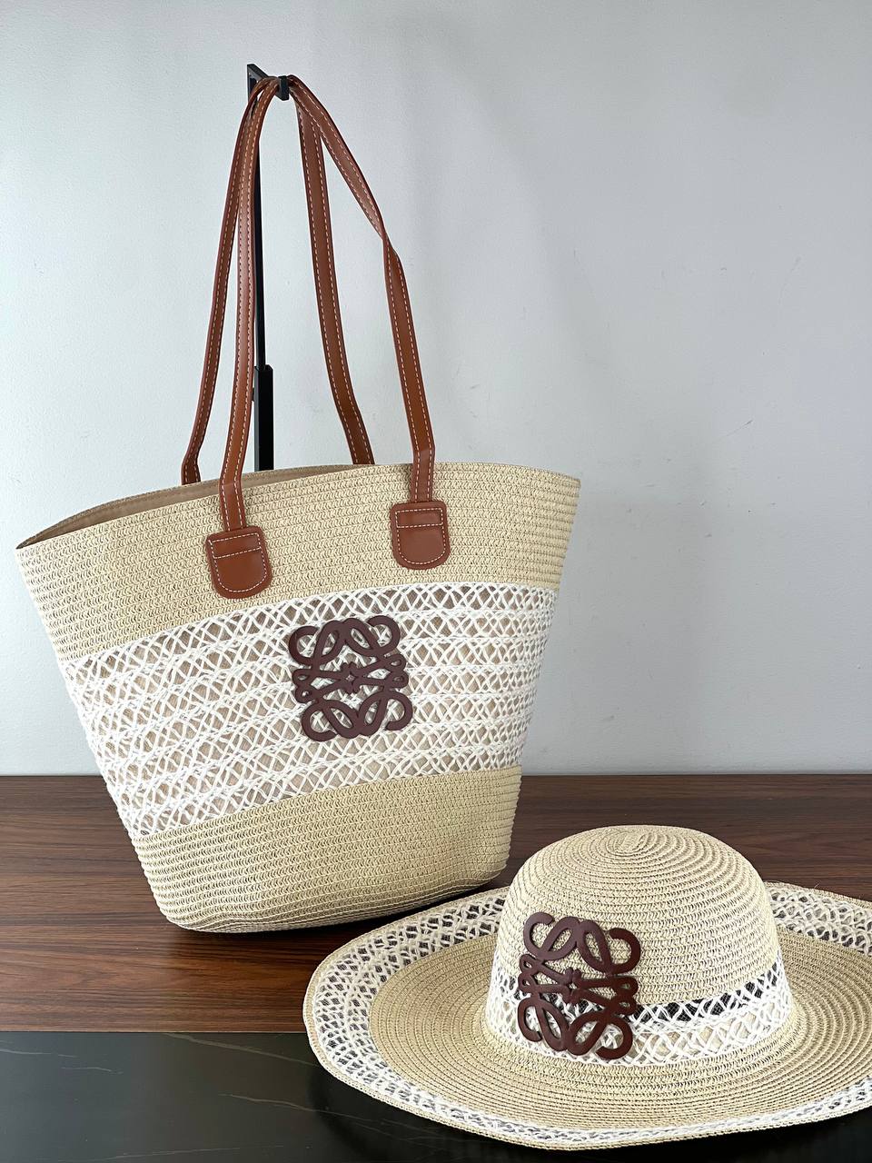 Woven tote bag and hat with lace details on a wooden surface