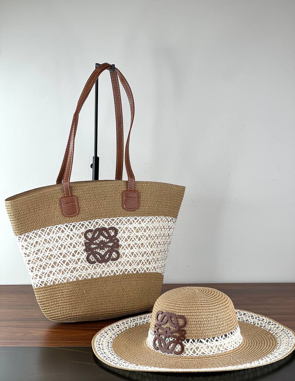 Woven bag and hat set with lace details on a wooden surface.
