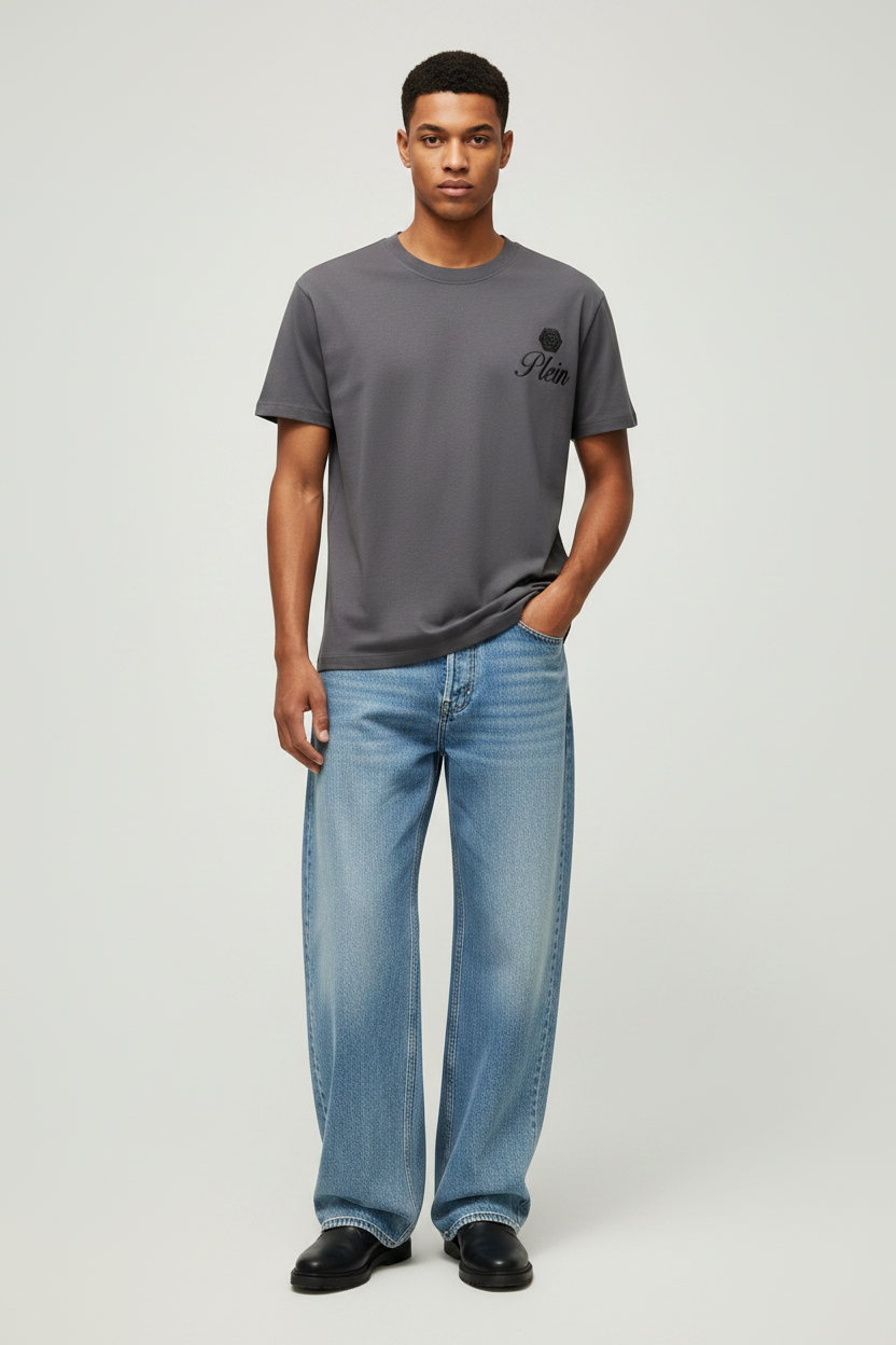Man wearing a gray t-shirt and blue jeans on a light gray background
