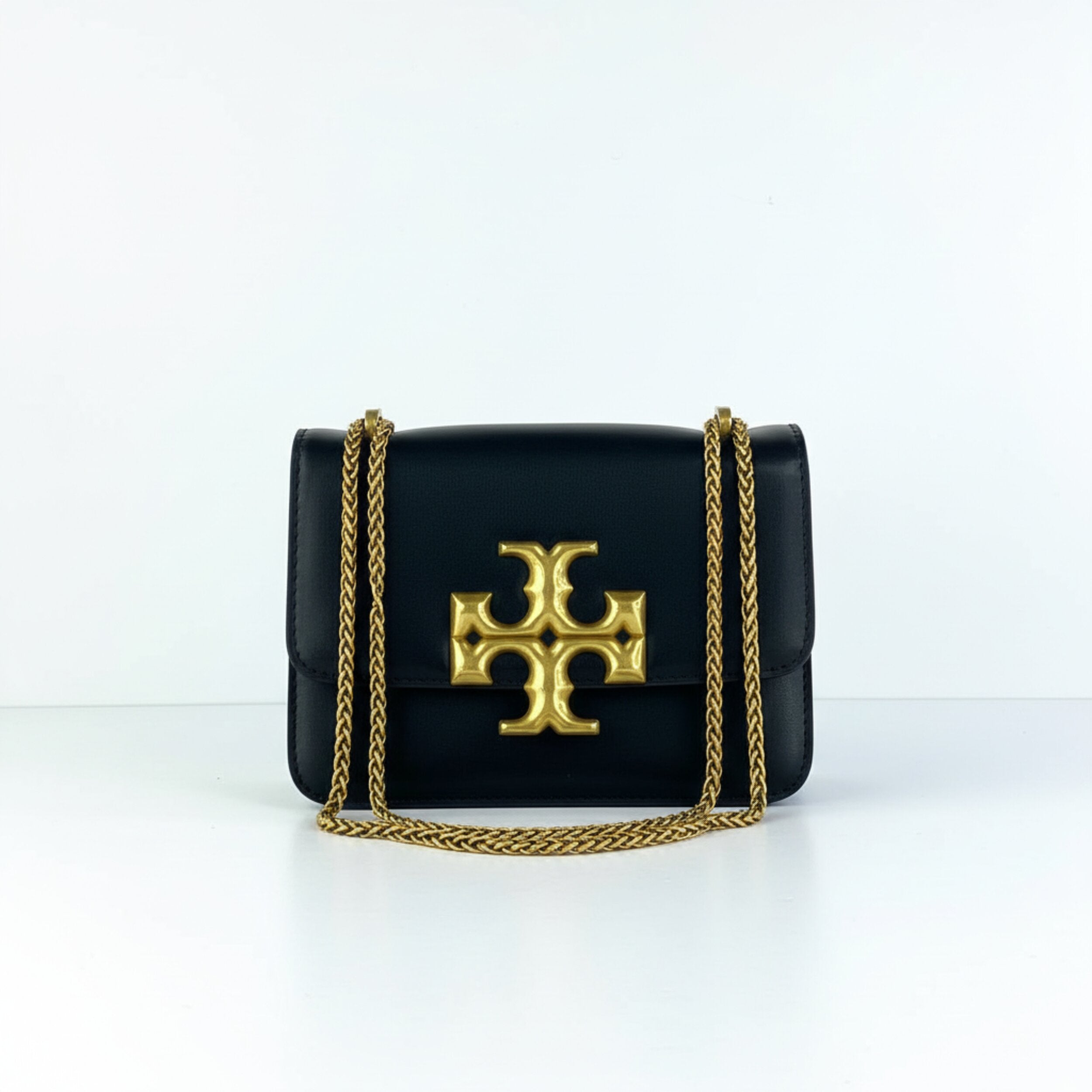 Tory Burch Eleanor black leather crossbody bag with oversized gold TB logo and chain strap
