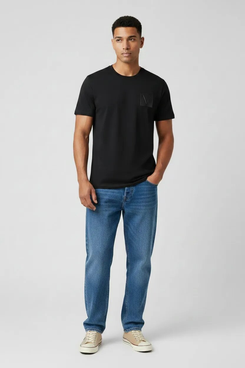 Man wearing a black t-shirt and blue jeans on a white background